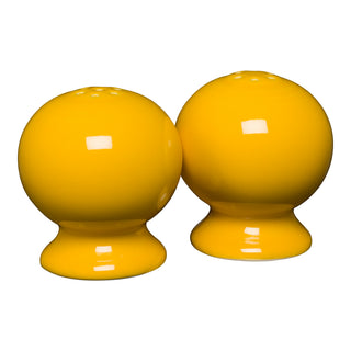 The Retired Fiesta 2 5/8 Inch Salt and Pepper Shaker Set in Daffodil, featuring a glossy round design, is shown side by side on a white background.