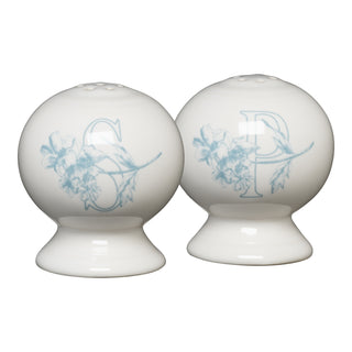 The Fiesta Botanical Floral Sky 2 5/8 Inch Salt and Pepper Shaker Set includes two round white ceramic shakers with wide bases, light blue floral designs, and "S" and "P" letters on the front.