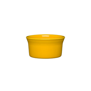 The Retired Fiesta 8 OZ Ramekin, 4 inch by Fiesta, is a small round ceramic dish in Daffodil yellow with slightly flared sides. Oven safe and made in the USA, it is shown on a white background.