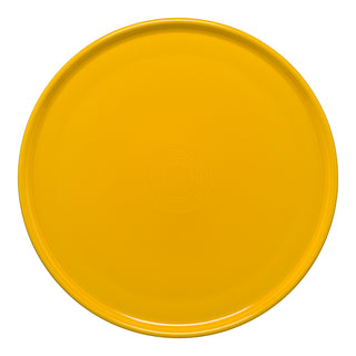 The Retired Fiesta 12 Inch Round Baking and Serving Platter by Fiesta, in daffodil yellow lead-free china, features a glossy finish with subtle concentric circles at the center and is shown from above on a white background.