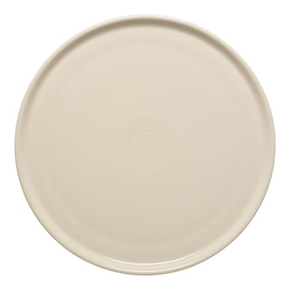 The Fiesta 12 Inch Round Baking and Serving Platter in Linen is a cream-colored ceramic plate with subtle concentric circles, oven safe and perfect as a baking tray, shown from above on a white background.