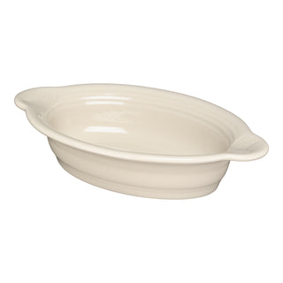 The Fiesta 9 1/8 Inch Oval Individual Casserole (13 oz) in Linen features shallow sides and dual handles, ideal for oven-to-table serving. This off-white ceramic bakeware is shown on a plain white background.