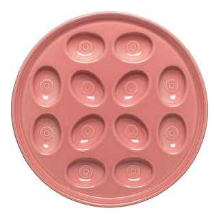 The Fiesta Retired Round Egg Serving Platter in Peony is an 11 1/4" pink ceramic plate with twelve oval indentations for deviled eggs, crafted from lead-safe china and made in the USA.