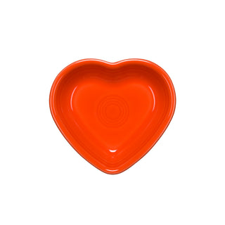 The Fiesta Retired Small Heart Bowl, shown from above in bright orange ceramic with a glossy finish and concentric circles, makes a charming jewelry holder or thoughtful hostess gift against a white background.