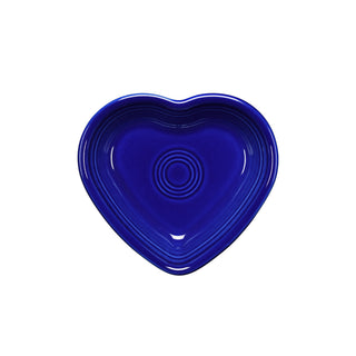 The Fiesta Retired Small Heart Bowl is a deep blue ceramic dish featuring concentric circles, ideal as a jewelry holder or hostess gift. Shown from above on a white background.