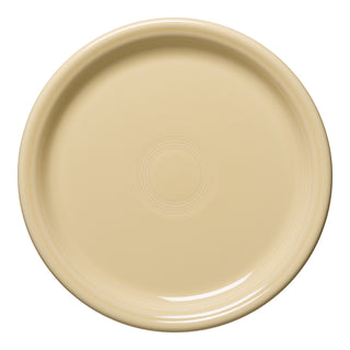 The Fiesta Retired Bistro Coupe 10 1/2 Inch Dinner Plate in ivory, made in the USA, features subtle concentric patterns in the center and at the rim, displayed from a top-down view.