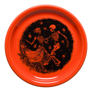 The Fiesta Skeleton Duet Poppy Bistro Coupe 9 Inch Luncheon Plate, made in the USA, features two dancing skeletons with floral accents on vivid orange vitrified china for a festive, durable design.