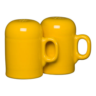 The Fiesta Retired 4 5/8 Inch Rangetop Large Salt and Pepper Shaker Set in Daffodil features two glossy, mug-shaped ceramic shakers made from vitrified china, shown side by side on a white background. Made in the USA.
