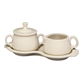 The Fiesta Retired Linen 4-Piece Sugar Bowl and Creamer Set with Tray features a cream-colored sugar bowl (with lid), creamer, and matching tray, all made in the USA. Shown on a white background.
