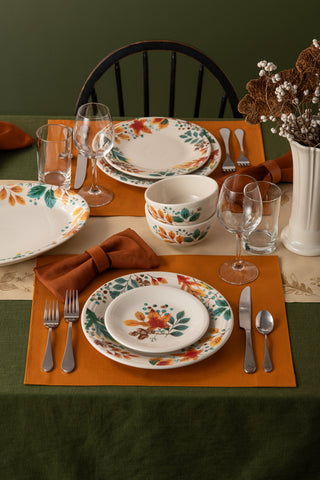 A fall table setting features Fiesta Autumn Fields Bistro Coupe 5 1/2 Inch Cereal Bowls, microwave safe and decorated with autumn leaves, paired with orange napkins in bows and a vase of dried flowers for a festive touch.