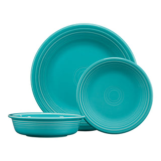 Three turquoise ceramic dishes: a large dinner plate, a smaller salad plate, and a shallow bowl, all with a smooth finish and concentric ring patterns near the edges.