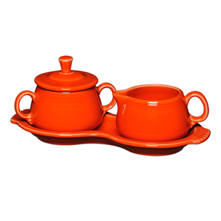 The Fiesta Retired 4-Piece Sugar Bowl and Creamer Set with Tray features a lead-safe orange sugar bowl with lid, a matching handled creamer, and an orange tray, all displayed against a white background.