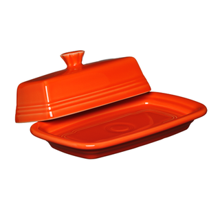 A retired Fiesta Extra Large Covered Butter Dish in vibrant Poppy, 8 1/8" x 5 1/8", made in the USA. It has smooth, rounded edges and a lid with a small knob handle, shown partially lifted to reveal the shallow rectangular base.