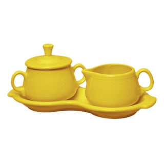 The Fiesta Retired 4-Piece Sugar Bowl and Creamer Set with Tray features a glossy, bright yellow, lead-safe china set with handled lidded sugar bowl, creamer pitcher, and matching tray.