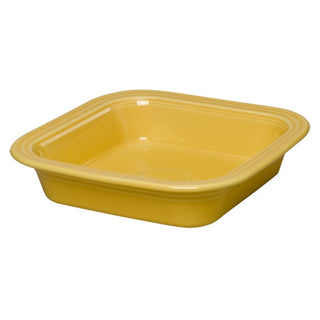 The Retired Fiesta Square 9x9 Inch Baker 2 Quart by Fiesta is a yellow ceramic baking dish with rounded corners and a glossy finish, made in the USA, shown from an angle.