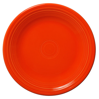 A bright orange ceramic plate with a glossy finish and circular ridged patterns around the rim, shown from a top-down view on a white background.