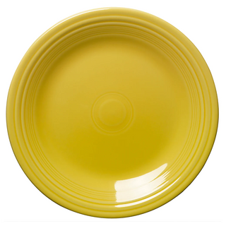 A round, yellow ceramic plate with concentric circle designs near the rim, shown from above against a white background.