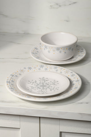 The Fiesta White Snowflake Classic Rim 7 1/4 Inch Salad Plate, with elegant blue and gold snowflake patterns, makes a perfect addition to your holiday tableware collection.