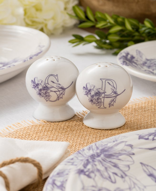 The Fiesta Botanical Floral Lavender 2 5/8 Inch Salt and Pepper Shaker Set features white ceramic shakers with purple floral designs, perfectly complementing matching Fiesta Dinnerware for a charming, Art Deco-inspired dining table.
