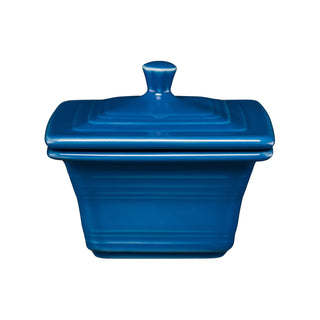 The Retired Fiesta Covered Box by Fiesta, in lapis, measures 4 5/8" x 3 3/4". Made in the USA, this square ceramic box with lid is shown against a white background—ideal as a stylish storage container.