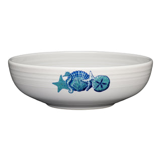 The Fiesta Retired Coastal Bistro Coupe 9 5/8 Inch Large Bowl (68 oz), crafted in the USA from vitrified lead-free china, is shown from the side against a plain white background, featuring blue and teal seashell and starfish designs on its white ceramic surface.