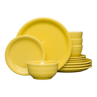 The Bistro Coupe 12-Piece Dinnerware Set by Fiesta (FTC) in sunflower features modern ceramic plates and bowls, stacked and arranged on a white background, capturing the vibrant style of classic Fiesta dinnerware.