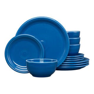 The Fiesta Bistro Coupe 12-Piece Dinnerware Set in lapis, service for 4, features plates and bowls neatly stacked and arranged on a white background.