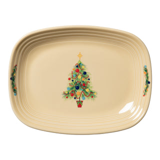 The Fiesta Christmas Tree 12 Inch Large Rectangular Platter is cream-colored, made in the USA, and features a central Christmas tree with ornaments and star, plus holly designs on each side.