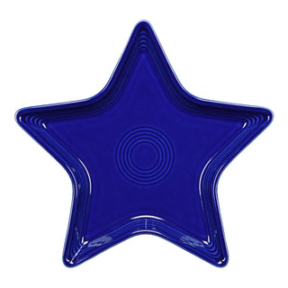 The Fiesta Retired Star Plate in twilight is a deep blue, star-shaped ceramic plate with concentric circular patterns, made from lead-safe china and shown from above on a white background.