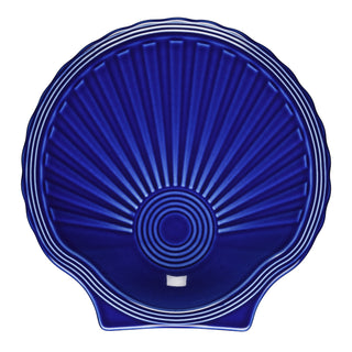The Fiesta Retired Shell Shaped Plate 8 1/4 OZ in twilight features a deep blue, scallop shell design with radiating ridges and concentric center circles. Glossy and lead-safe, it’s a beautiful collectible china item.