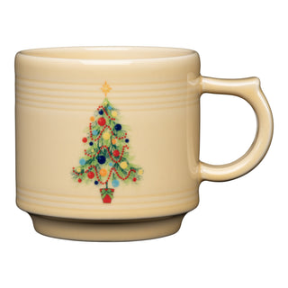 The Fiesta Christmas Tree 16 OZ Stackable Mug is a beige vitrified china ceramic mug made in the USA, featuring a decorated Christmas tree with ornaments, garlands, and a star. Dishwasher safe for easy cleaning.