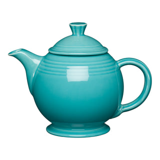The Retired Fiesta 44 OZ Covered Teapot by Fiesta, in turquoise, features a round body, curved handle, short spout, and matching lid. This lead-safe china teapot is dishwasher safe for easy cleaning and shown against a white background.