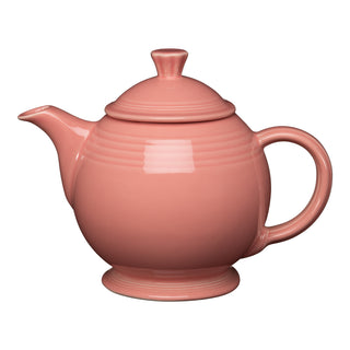 The Retired Fiesta 44 OZ Covered Teapot in peony has a round body, curved spout, large handle, and matching lid. Made from lead-safe china by Fiesta, it's photographed against a white background.