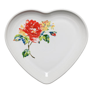 The Fiesta Retired Floral Bouquet 9 Inch Heart Shaped Plate features a colorful floral design with a vibrant red flower and green leaves. Made in the USA, this lead-safe ceramic plate is perfect for collectors of retired items.