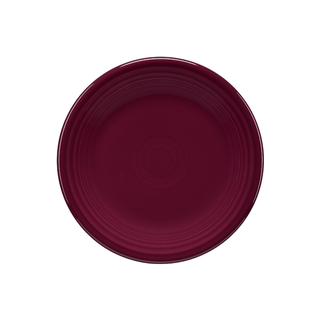 The Fiesta Retired Classic Rim 7 1/4 Inch Salad Plate in claret, made in the USA, features a smooth ceramic surface with subtle concentric circles and is shown from a top-down view on a white background.