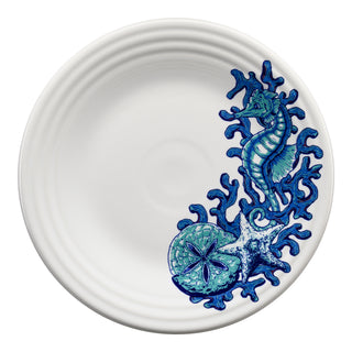 The Fiesta Retired Coastal Seahorse Classic Rim 9 Inch Luncheon Plate features a white ceramic base with blue and teal sea-themed designs—seahorse, starfish, sand dollar, and coral—along the edge. Dishwasher safe, it adds coastal charm to any setting.