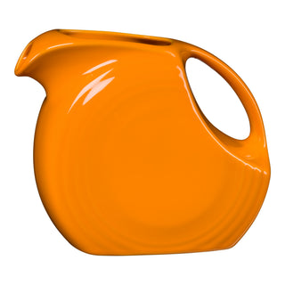 The Fiesta Retired 67 OZ Large Disk Pitcher in butterscotch is a lead-safe ceramic piece made in the USA, featuring a rounded body, integrated handle, and narrow spout. Shown on a plain white background.