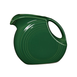 The Fiesta Retired Jade Small Disk Pitcher is a glossy jade vitrified china piece with a round body, curved handle, and Art Deco-inspired concentric circles.