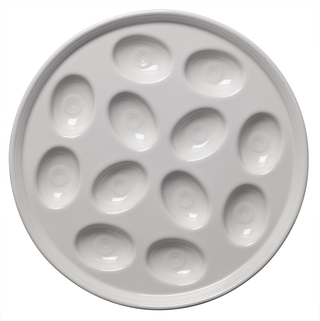 The Fiesta Retired Round Egg Serving Platter, 11 1/4 inch in white, features twelve oval indents—USA-made from lead-safe china—ideal for serving deviled eggs or other small treats.