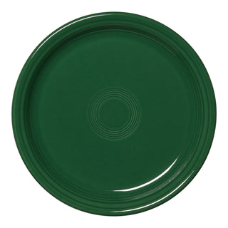 The Fiesta Bistro Coupe 9 Inch Luncheon Plate in jade is a round, dark green ceramic plate with a smooth surface and concentric circular ridges. Made in the USA, it features a plain design without patterns or extra decorations.
