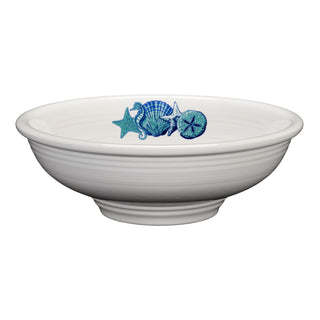The Retired Coastal Pedestal Bowl by Fiesta is a white ceramic bowl featuring blue and teal seashell and starfish designs along the inner rim, crafted in the USA from lead-safe china.