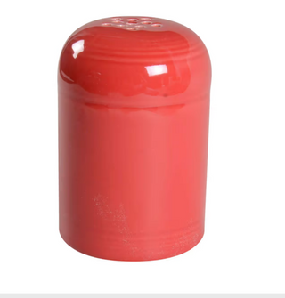 The Retired Fiesta Cheese Shaker by Fiesta, in scarlet ceramic, features a rounded top with small holes. Chip resistant and hand-finished, it's perfect for dispensing salt or pepper against a white background.